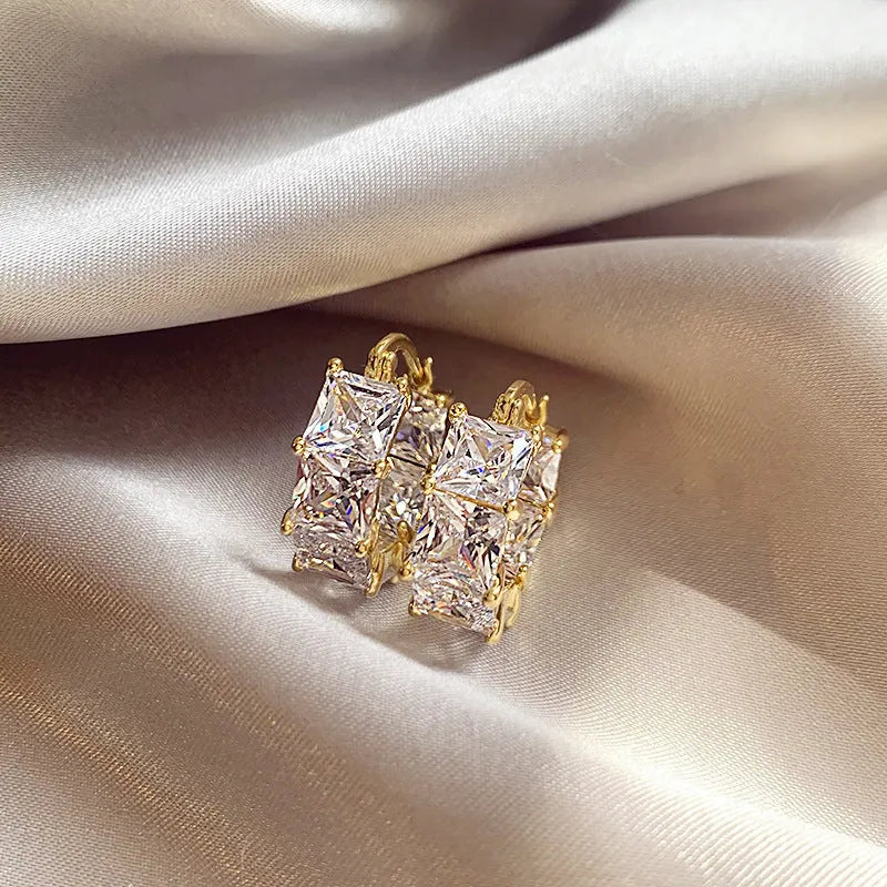 Geometric U-shaped gold electroplated copper ear rings with round black zircon settings