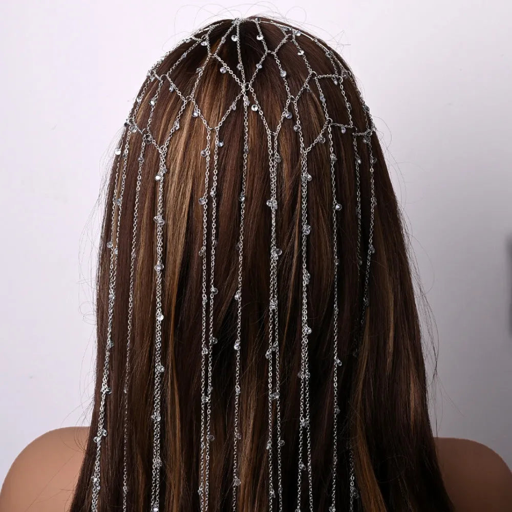 Gold metallic mesh headband with rhinestones and a dangling tassel decoration.