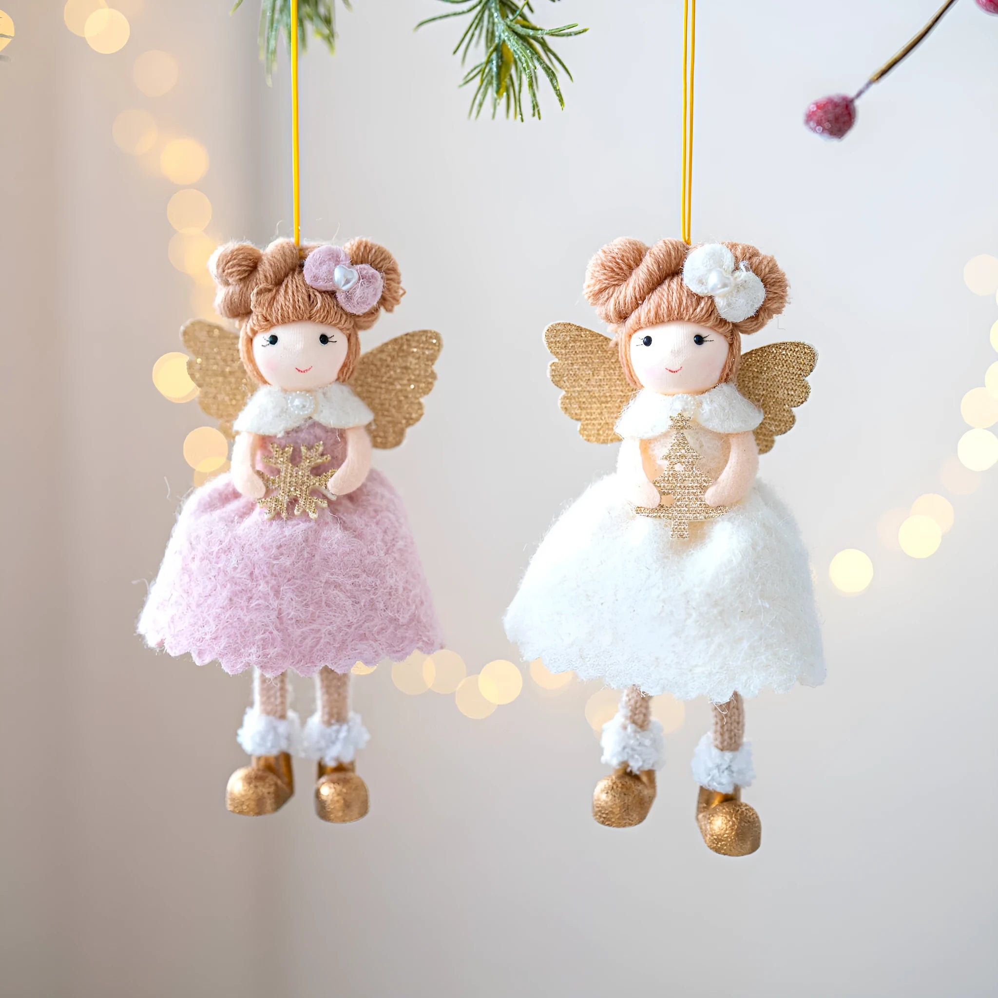 Pink and white cloth angel wings plush pendant Christmas ornament hanging against festive background