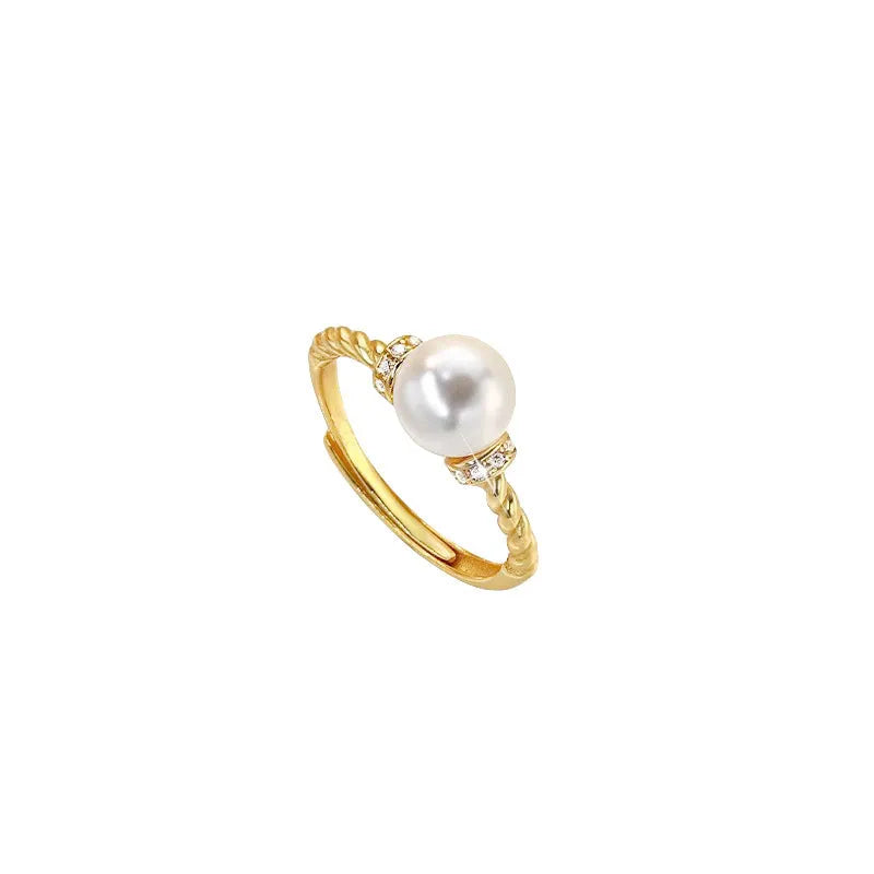 Adjustable geometric twist copper ring with a central pearl, shown in gold and silver colour options.