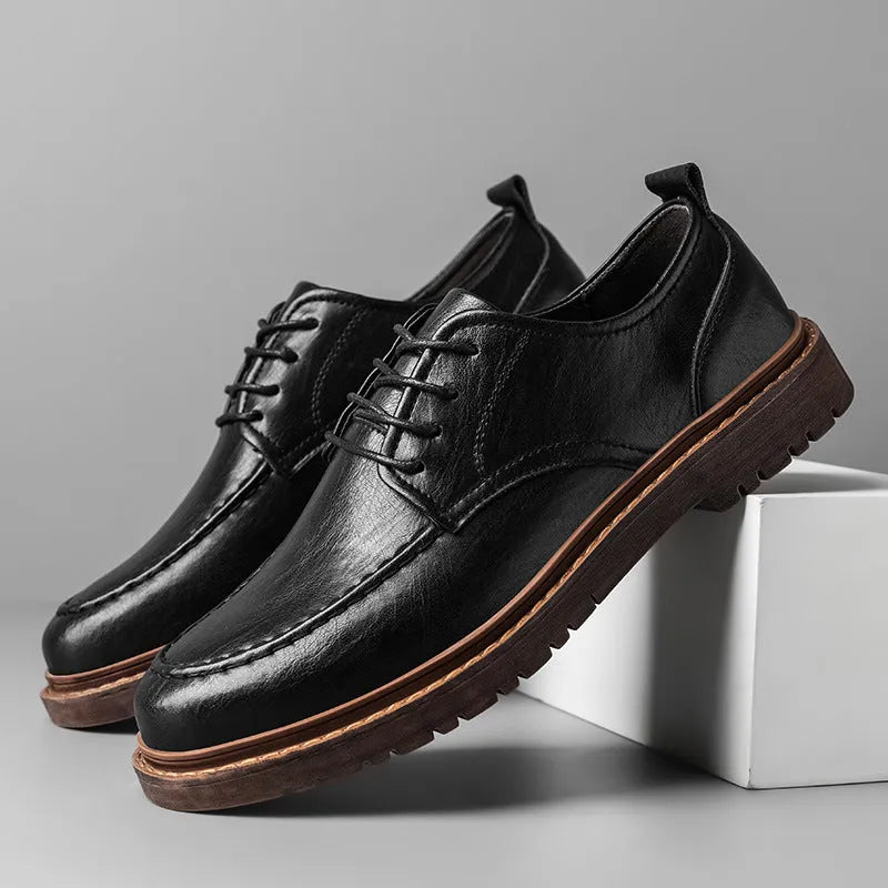 Men's black casual leather shoes with sewing line details and a round toe on a flat rubber sole.