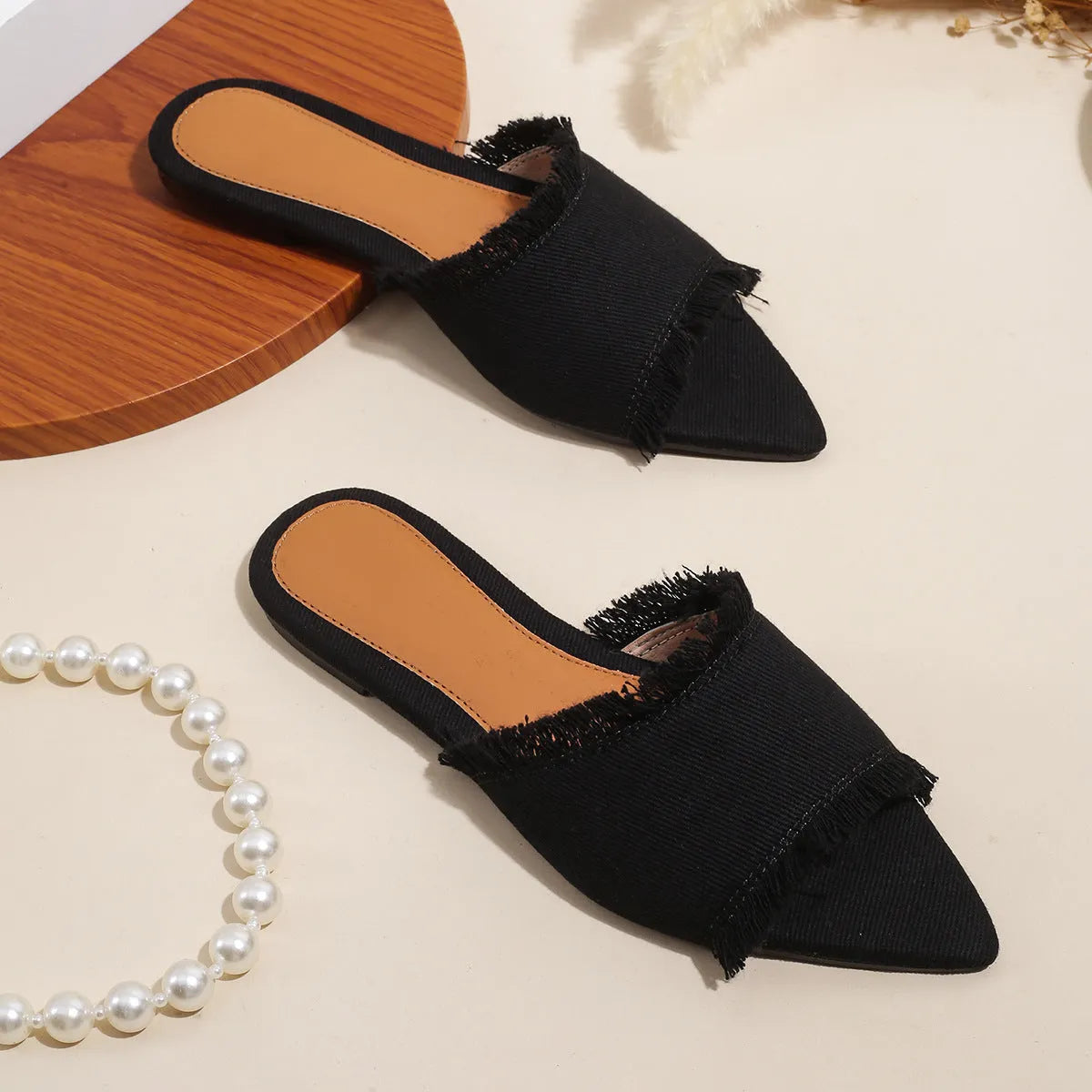 Women's denim flat slippers with a tassel, shown in available colours like apricot, black, and wine red.