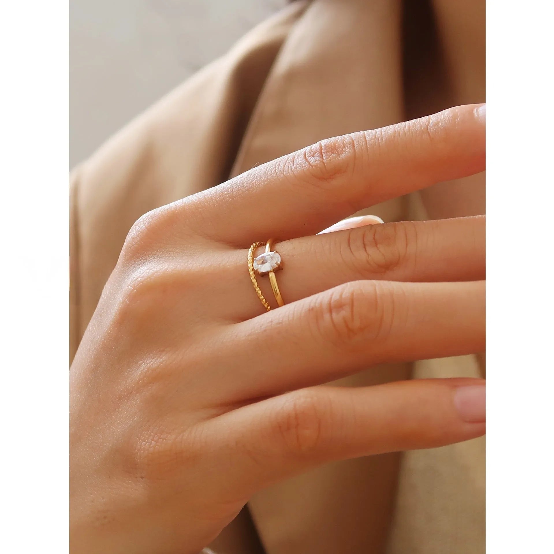 Golden electroplated stainless steel ring showing heart and oval shape designs on a hand.