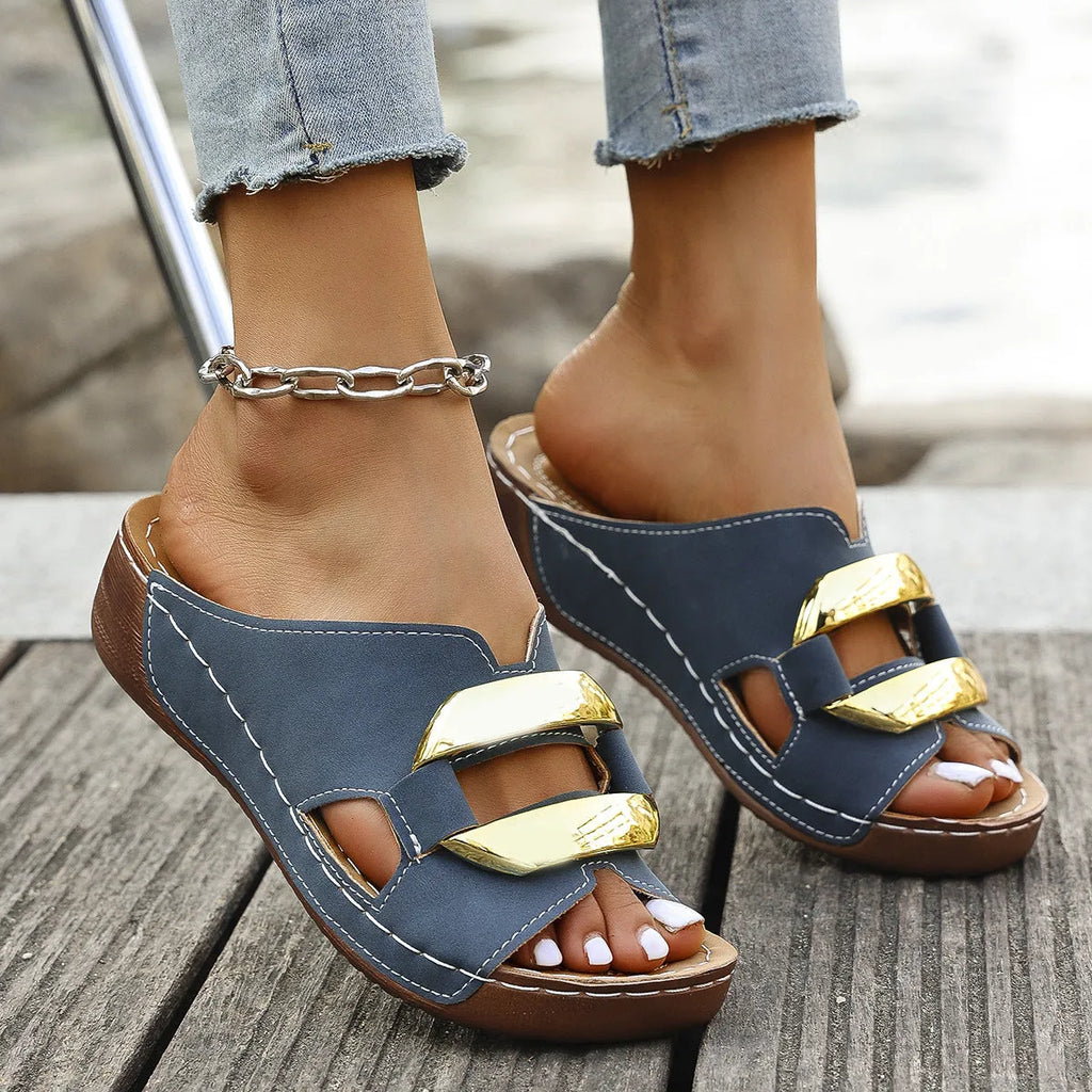 White Roman style platform sandals with flat heel and metal detail on a rubber sole.