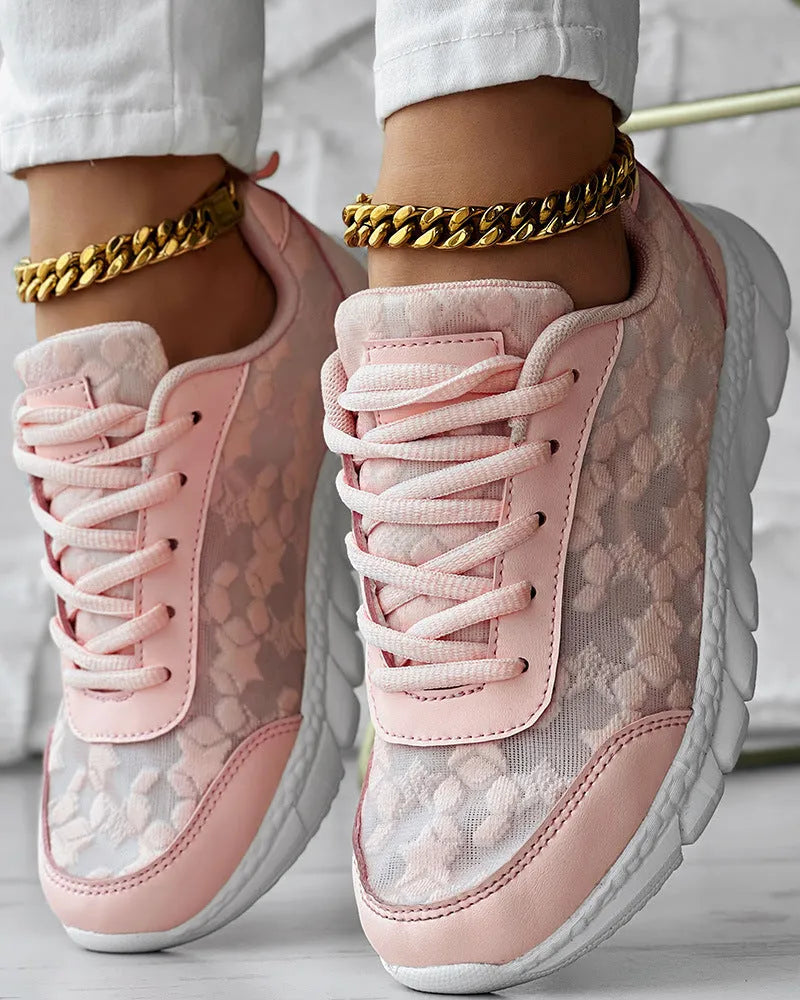 Women's white canvas running shoe with flat heel and round toe on a neutral background.