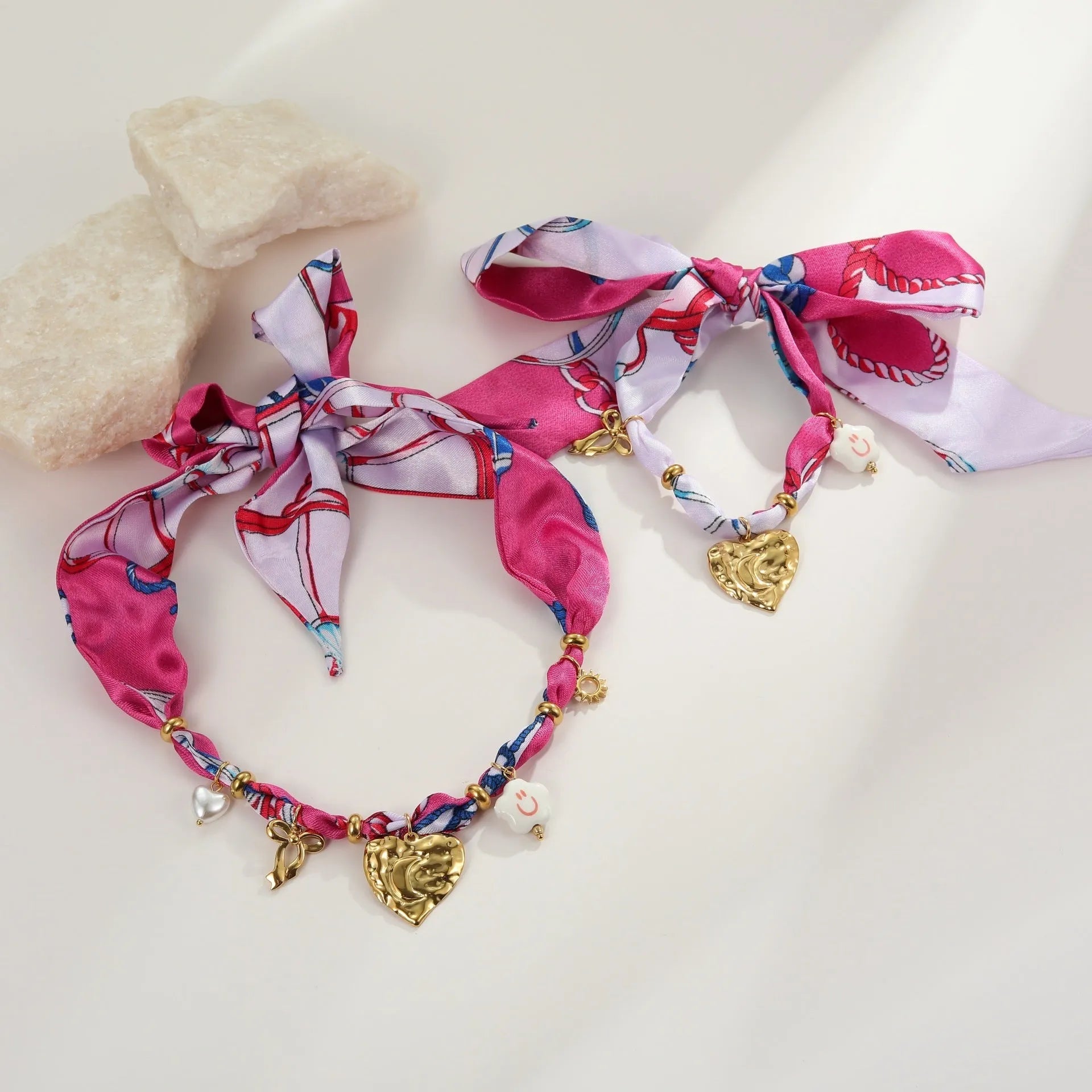 Stainless steel geometric pendant necklace and matching bracelet set with gold electroplating on a white background.