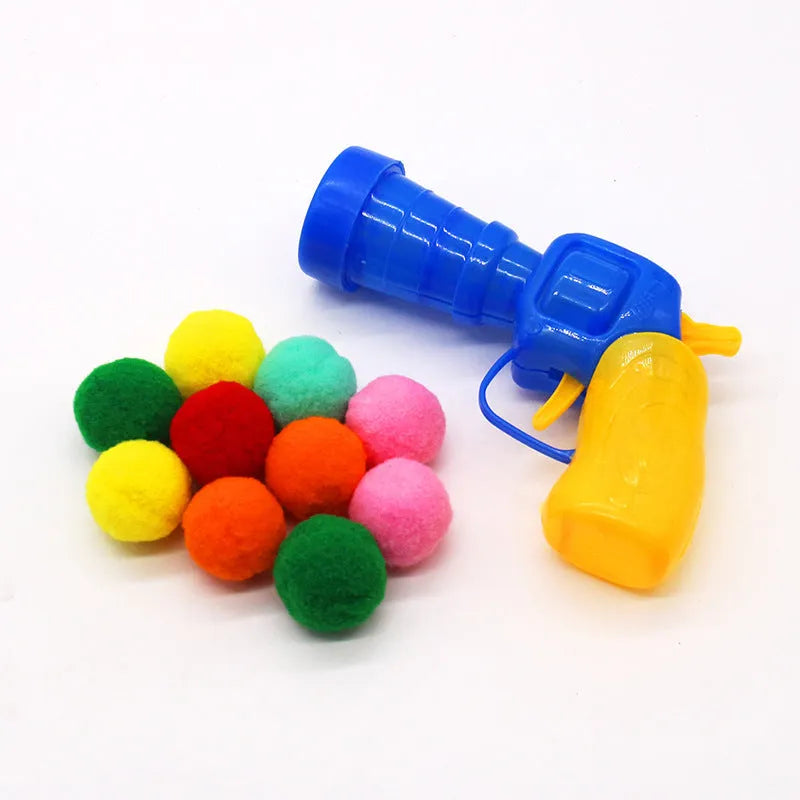 Plush ball launcher dog toy with soft pom-pom balls for indoor fetch games