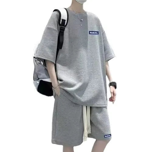 Man wearing a grey waffle-textured cotton leisure sports suit with short sleeves and shorts.