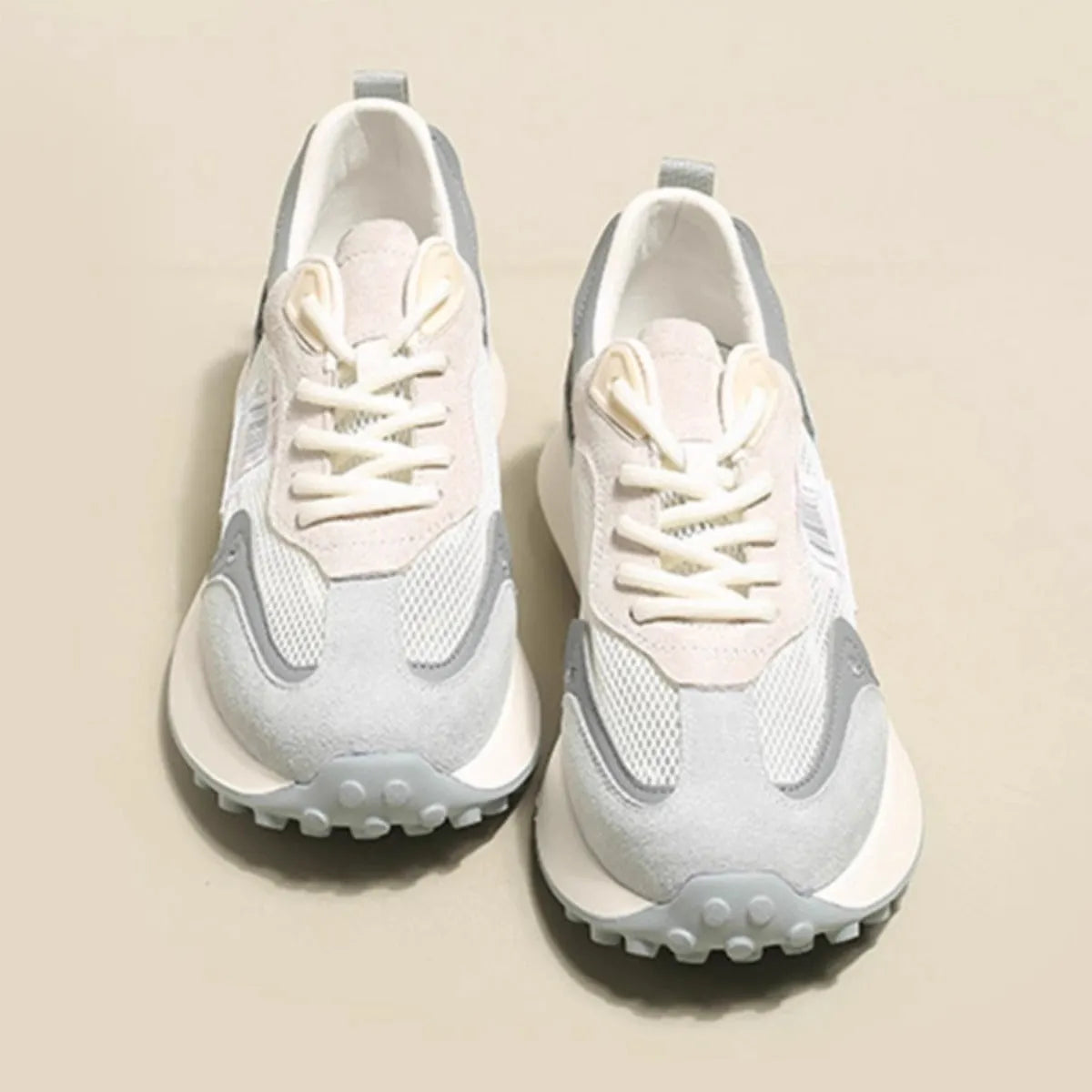Grey and pink women's low-top retro sneakers with round toe and shallow mouth on a rubber sole.