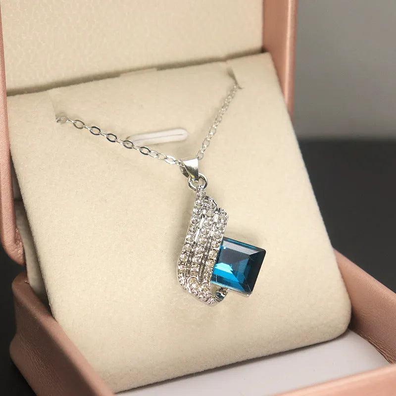 Women's cross chain necklace and earrings set with glass pendant and electroplated finish.