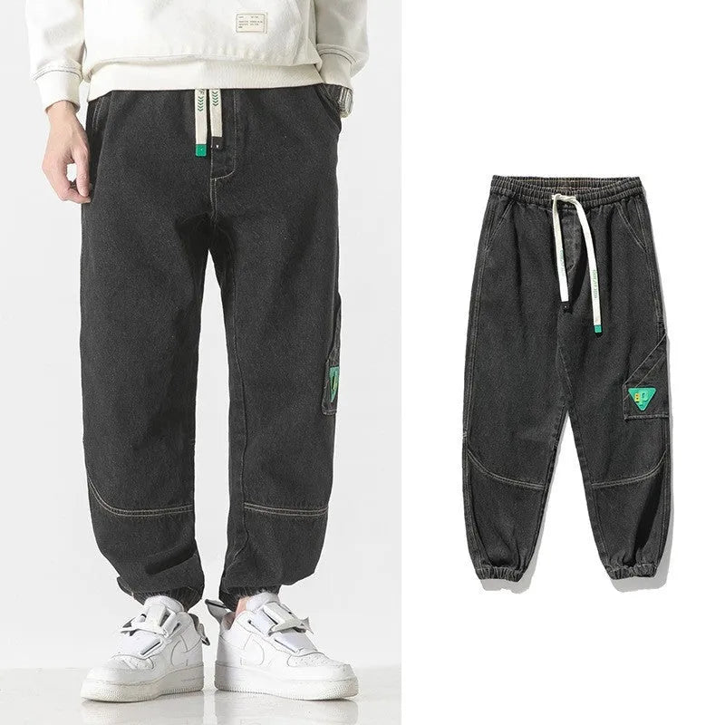 Men's loose-fit tapered cotton trousers in black colour showing mid-rise waist and tapered leg silhouette