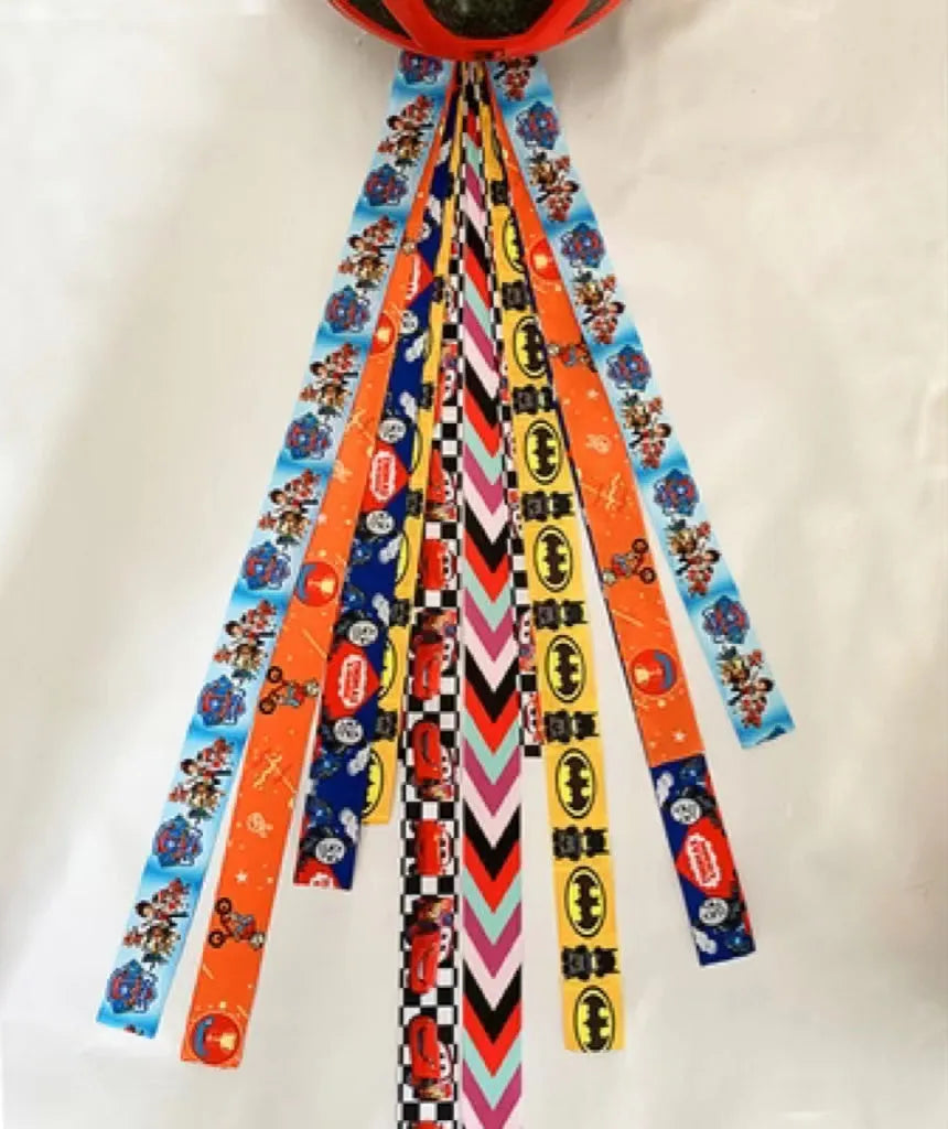 Close-up of a colourful decorative ribbon streamer attached to a child's helmet for roller skating or skiing.