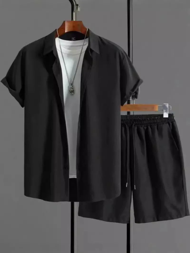 Man wearing a jacquard black short sleeve suit shirt with matching shorts from a two-piece set.