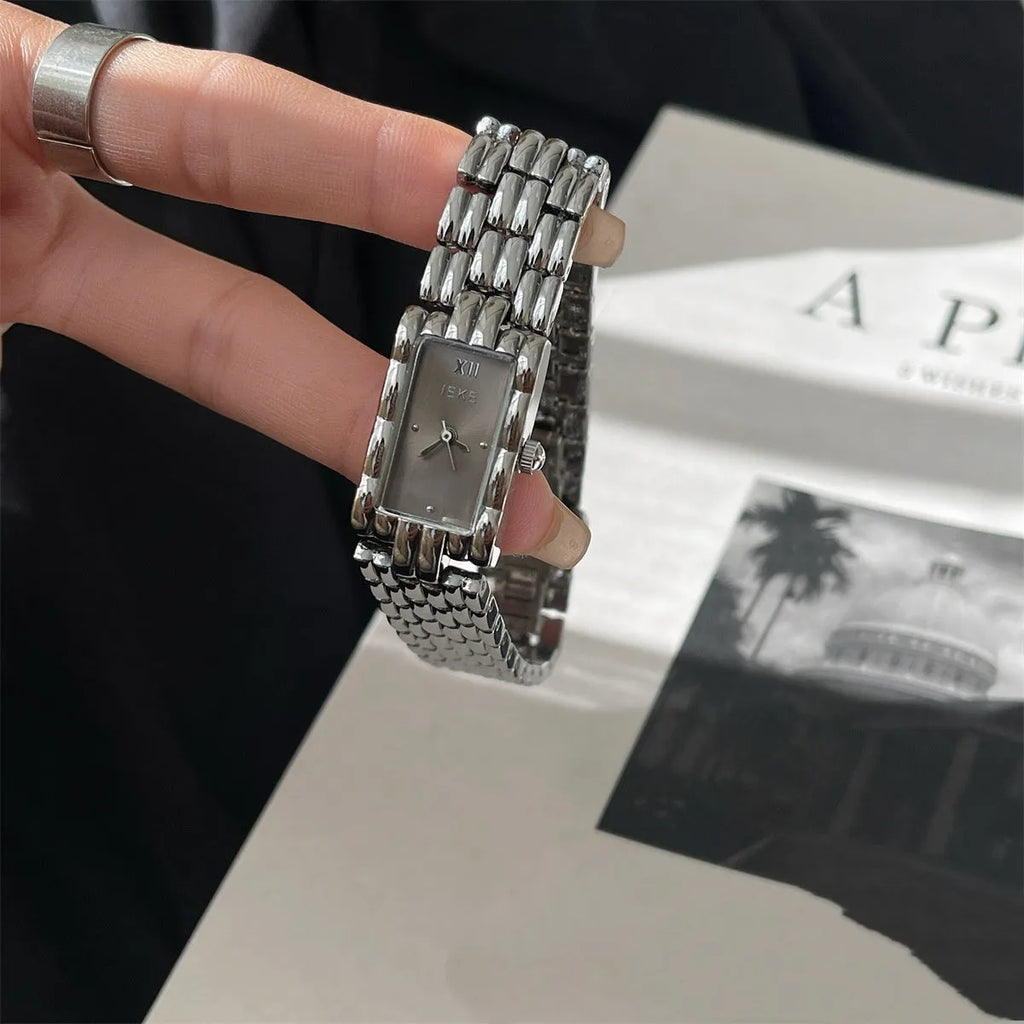 Women's vintage bracelet watch with a small dial, butterfly buckle, on a silver strap.