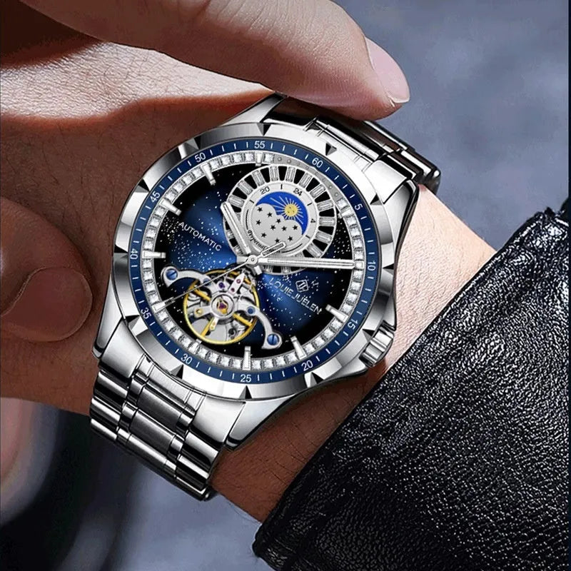 Men's silver automatic watch with blue dial and stainless steel strap showing transparent case back