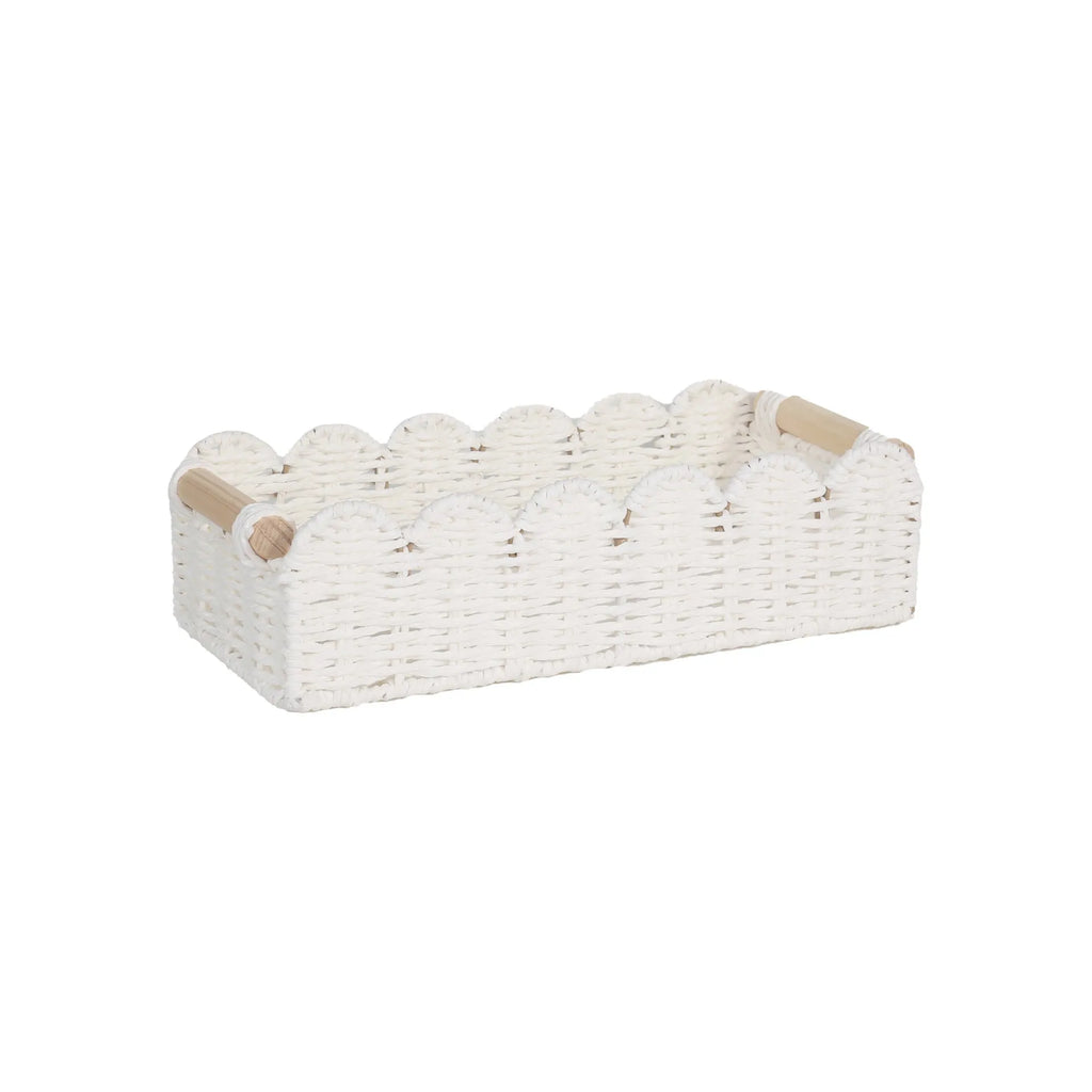 Modern woven paper storage basket in khaki colour on a wooden desktop, holding remote controls and pens.