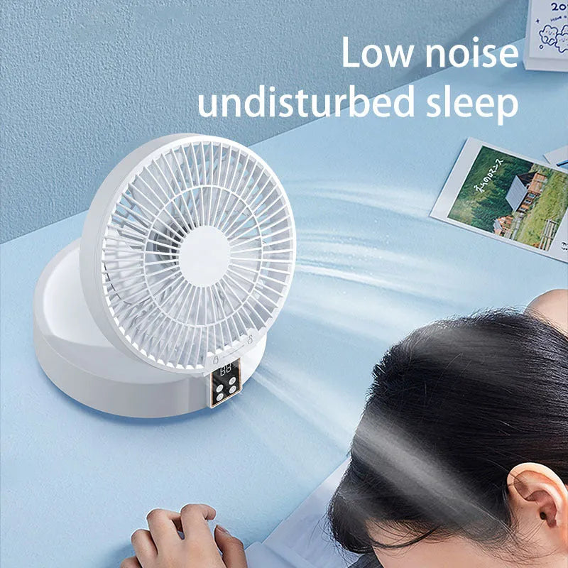 White portable USB rechargeable folding ceiling fan with remote control on desk