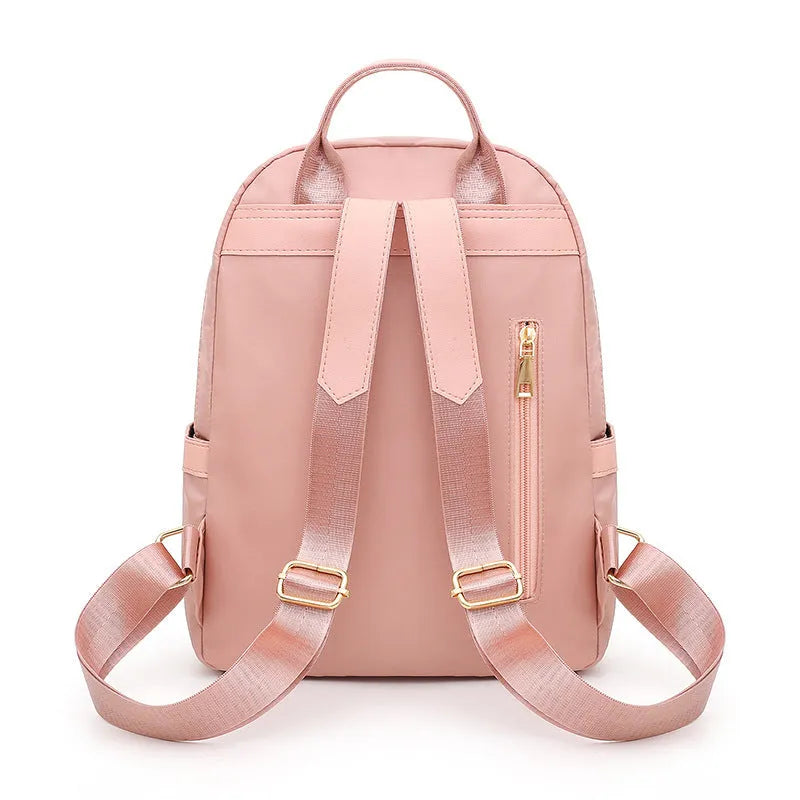 Women's black nylon casual backpack with double shoulder straps showing internal compartments and waterproof features