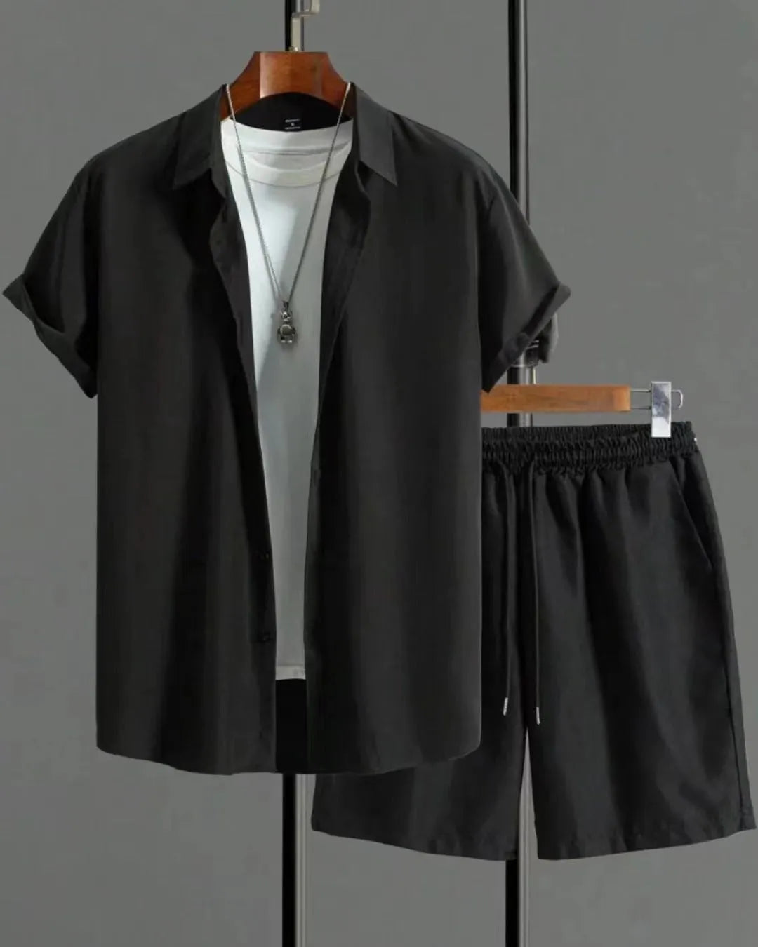 Man wearing a jacquard black short sleeve suit shirt with matching shorts from a two-piece set.
