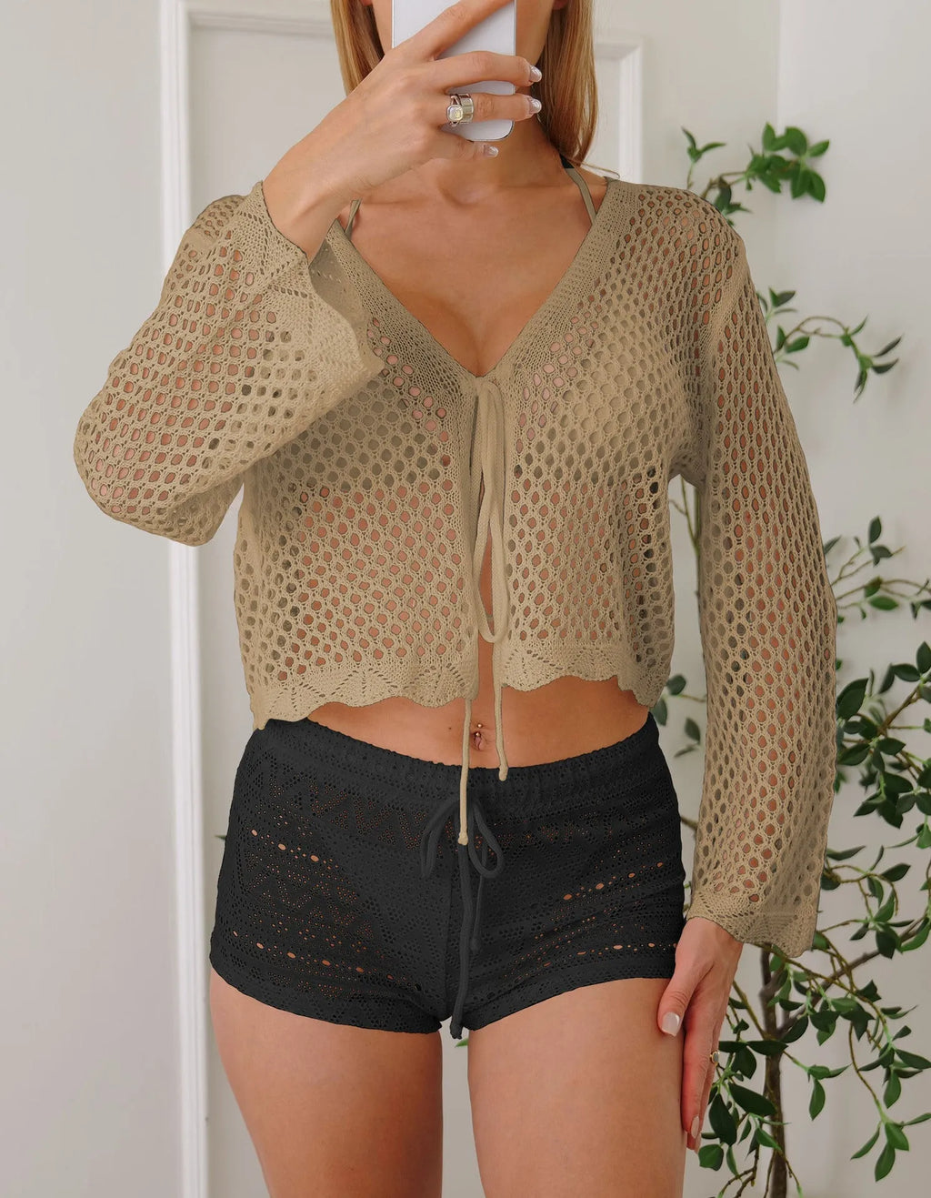 Women's short length cardigan blouse with nine-quarter bell sleeves in a hollow woven imitation cotton fabric.