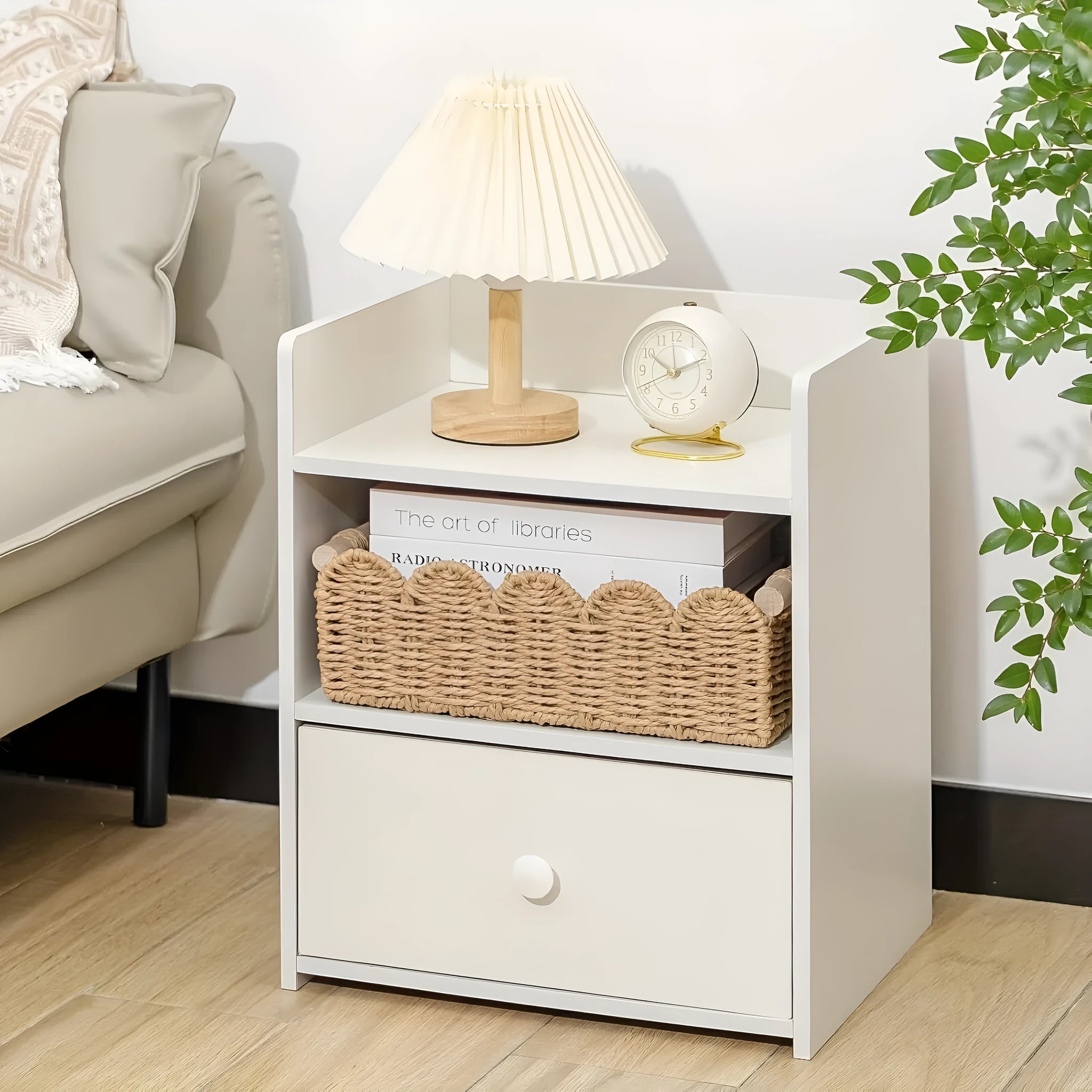 Modern woven paper storage basket in khaki colour on a wooden desktop, holding remote controls and pens.