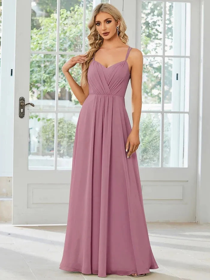 Women's light green sleeveless dress with sling neckline and long pleated A-line skirt.