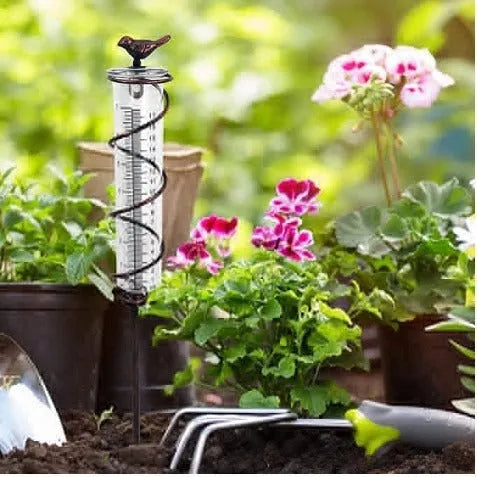 Cast iron bird-shaped garden rain gauge with glass measurement tube showing 1-20 scale