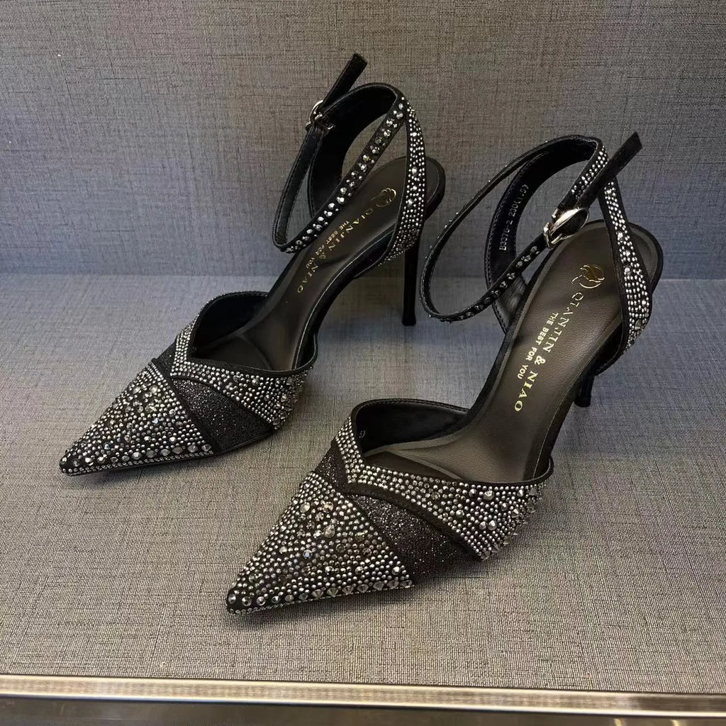 Women's silver high heel shoe with hollow stiletto heel, pointed toe, and bright red sole.