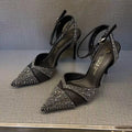 Women's silver high heel shoe with hollow stiletto heel, pointed toe, and bright red sole.