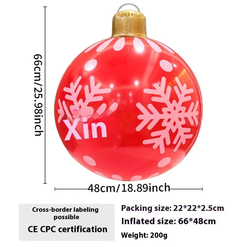 Large red inflatable Christmas ball with snowflake design and LED lights in outdoor garden setting