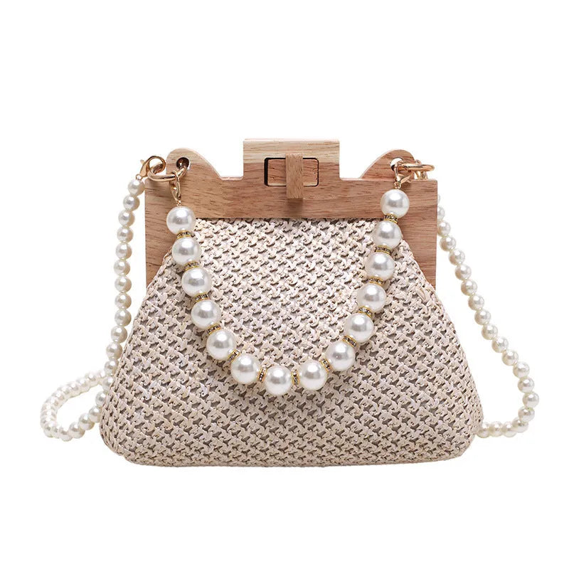 Women's woven straw shoulder bag with pearl chain strap showing interior organiser compartments