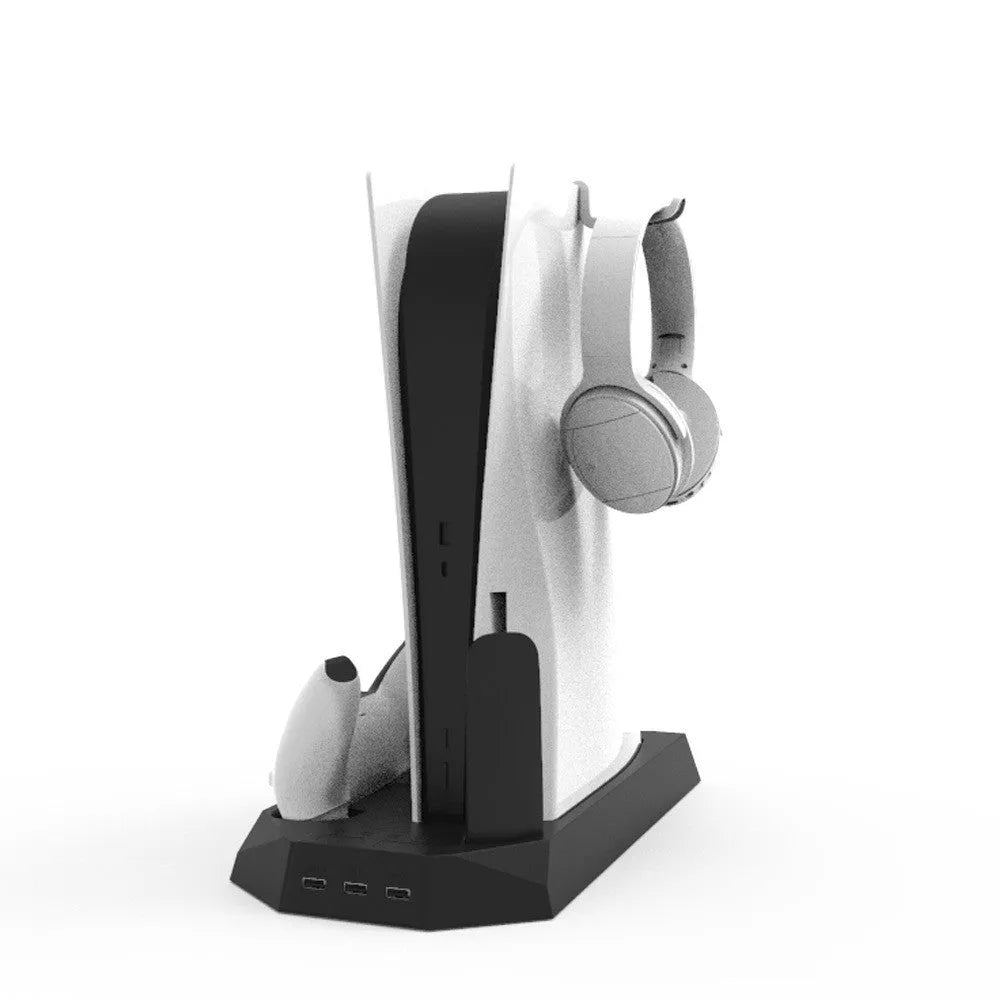 White PS5 charging stand with console upright, DualSense handle docked, and headset on hook.