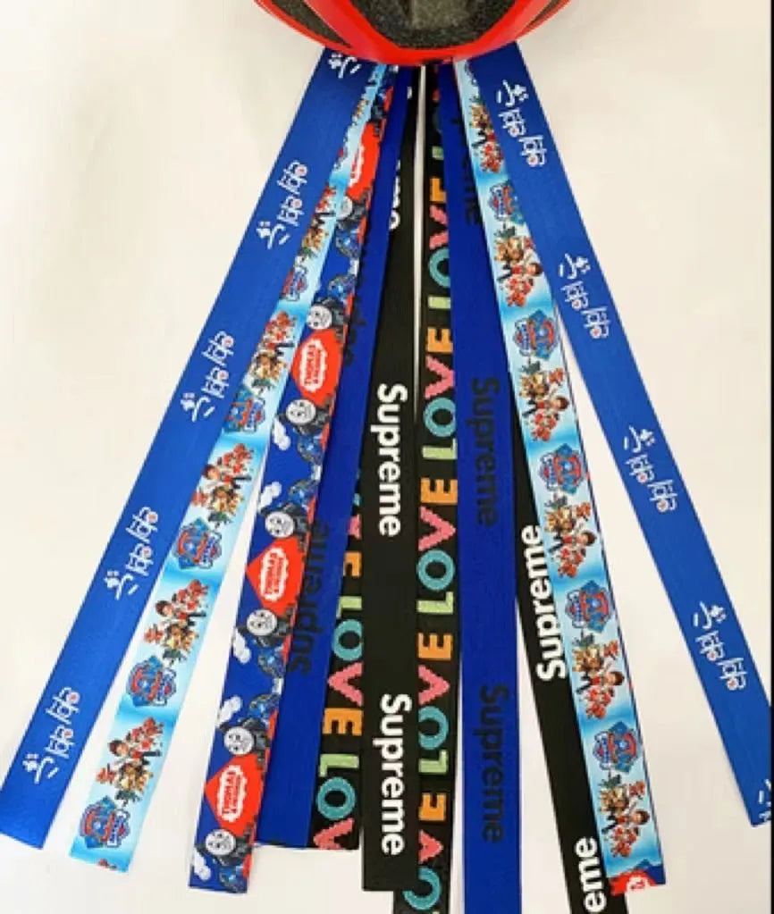 Close-up of a colourful decorative ribbon streamer attached to a child's helmet for roller skating or skiing.