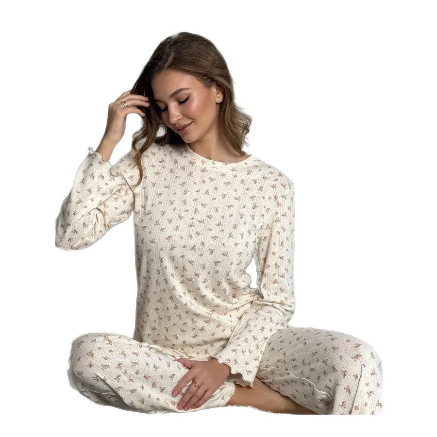 White women's floral print two-piece suit with bell sleeve top and wide leg pants on a hanger.