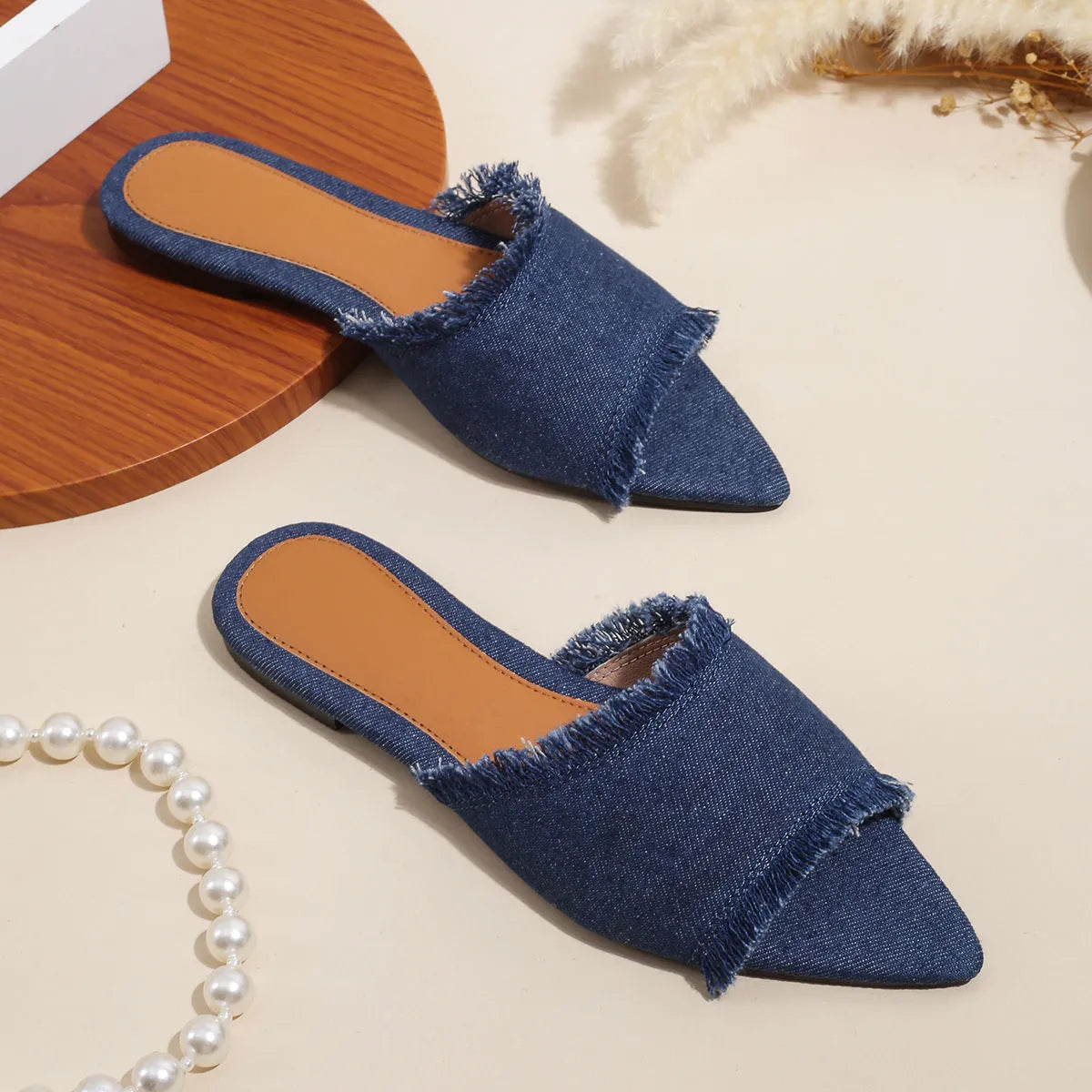 Women's denim flat slippers with a tassel, shown in available colours like apricot, black, and wine red.