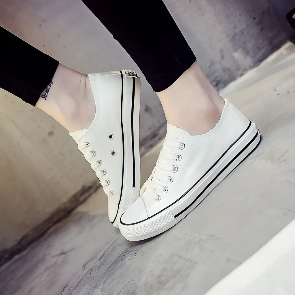 Solid colour canvas shoes for women on a plain background, showing the casual low-top design.