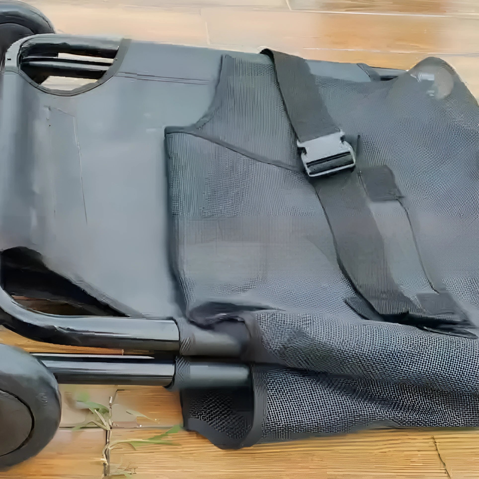 Black foldable aluminium alloy pet stretcher for large dogs, shown in emergency transport use.