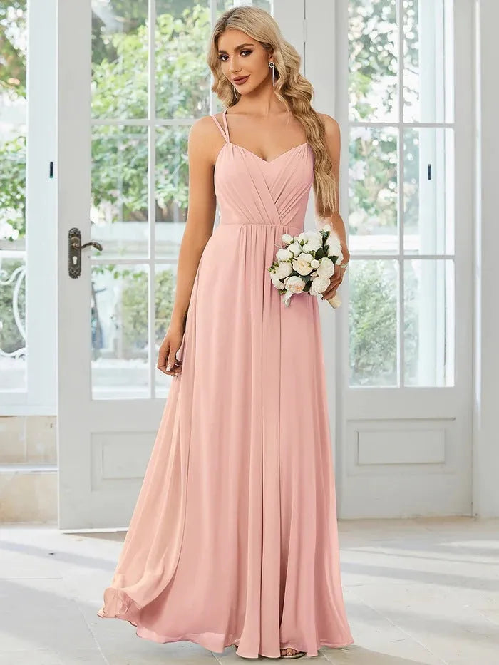 Women's light green sleeveless dress with sling neckline and long pleated A-line skirt.