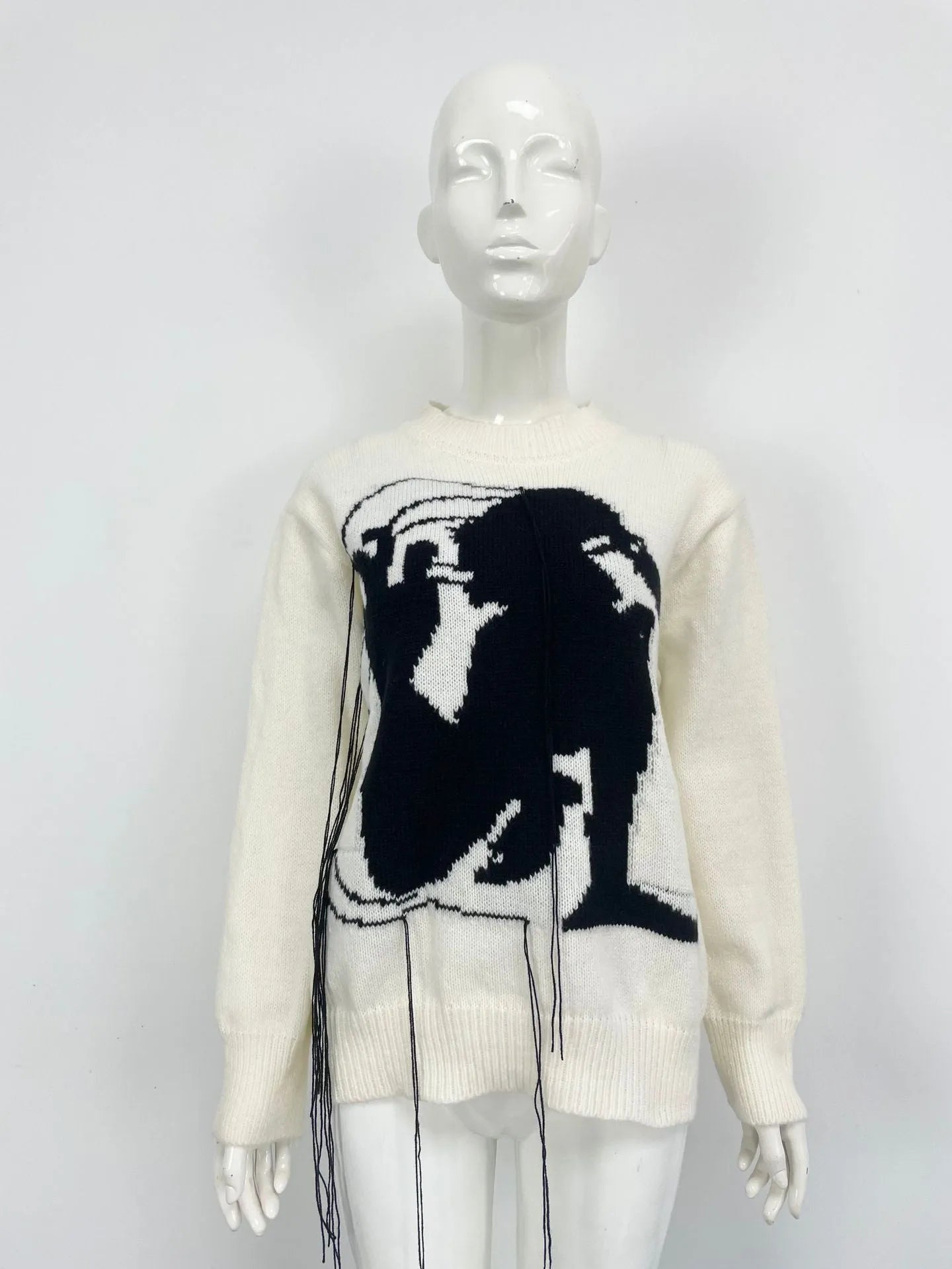 Grey women's loose alpaca wool sweater with a round neck, regular sleeves, and a long tassel detail.