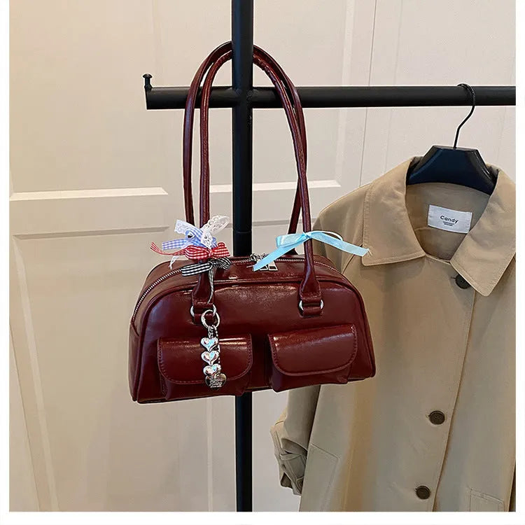 Brown PU leather retro pillow bag for women with a flap closure and double shoulder strap.