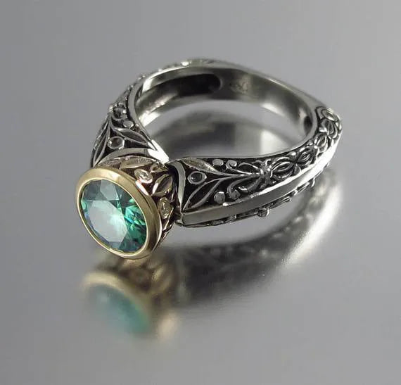 Gold-plated flower-shaped ring with emerald green gemstone in vintage design on finger