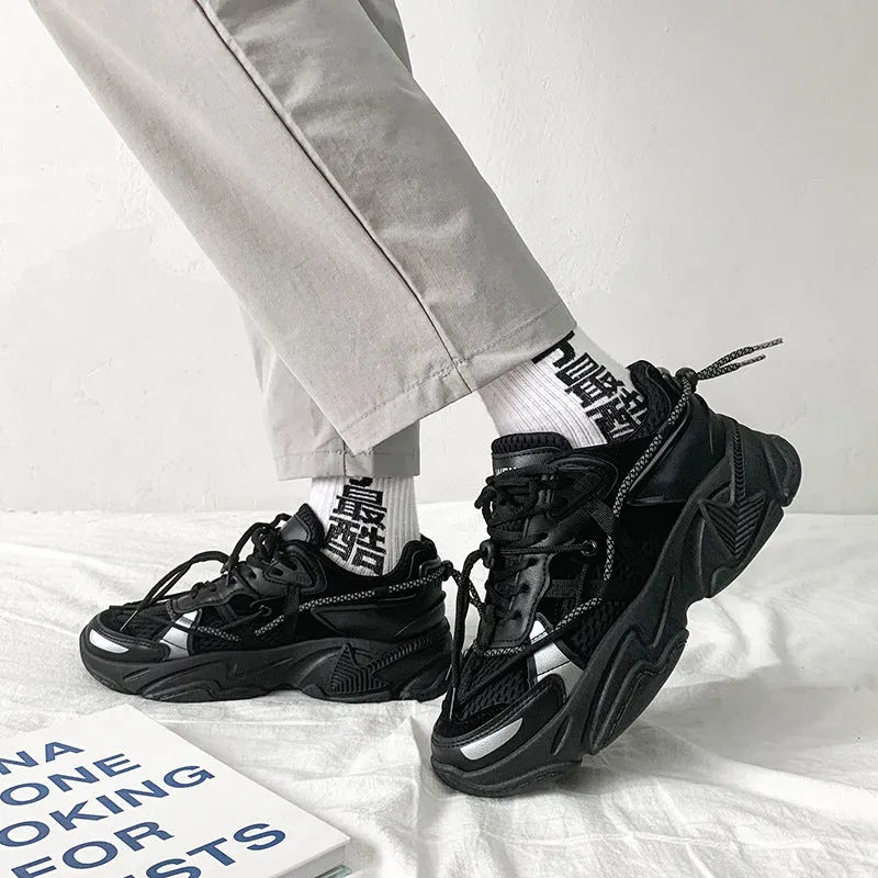 Men's black platform dad shoes with white soles and lace-up front, shown on a grey background.