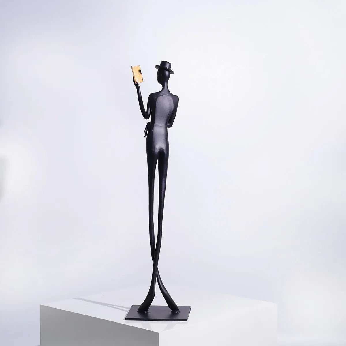 Black aluminium desktop sculpture of a woman reading, modern design.