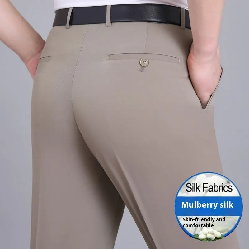 Man wearing dark blue straight-leg suit trousers with a high waist, made from a mulberry silk blend fabric.