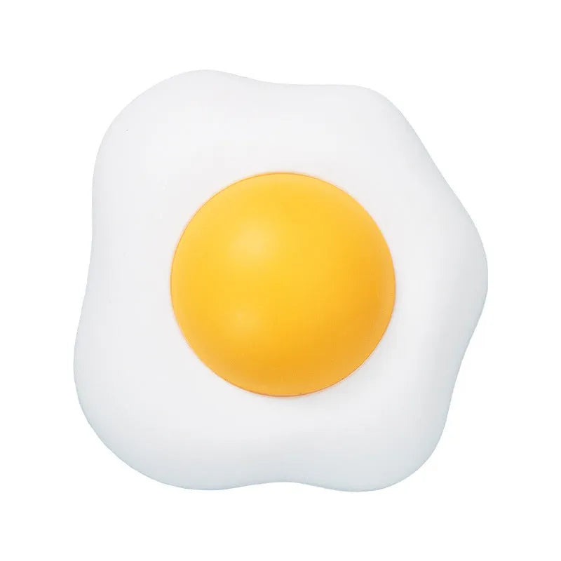 Soft plush catnip ball toy in fried egg shape stuck to a wall, with a cat playing.