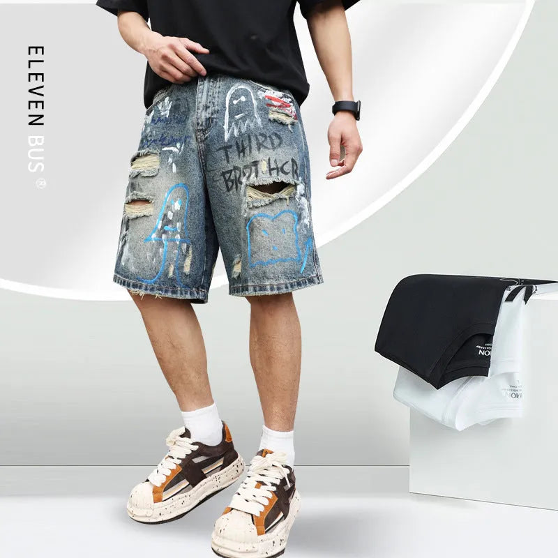 Blue ripped men's denim shorts with graffiti pattern and straight-leg cut.