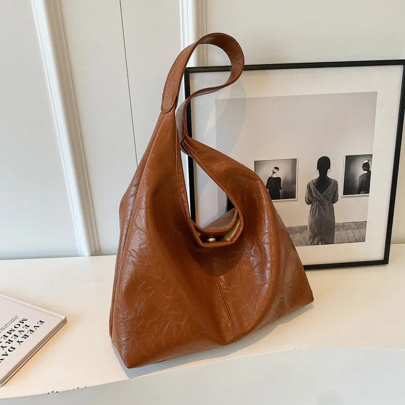 Soft leather shoulder bag in street style with sandwich pockets, shown in multiple colour options.