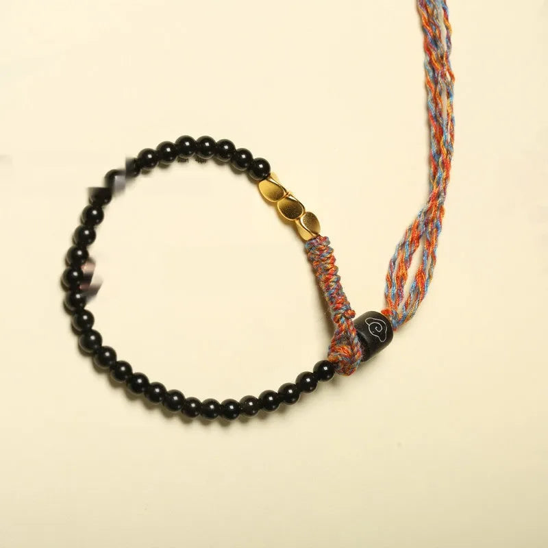 Hand-woven obsidian carrying strap bracelet showing textured weave and adjustable 15.5-16cm length