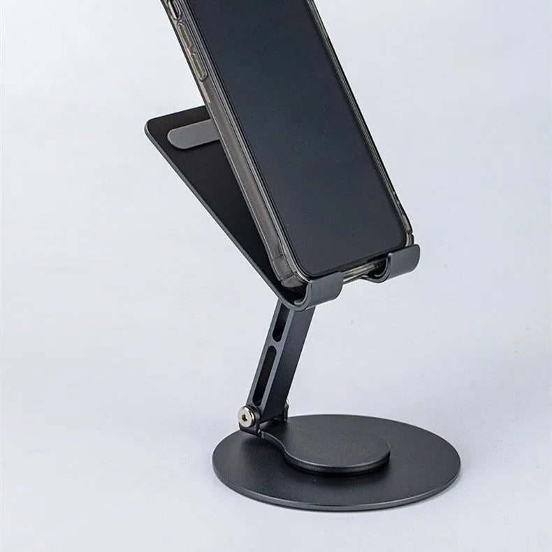 Aluminum alloy rotating mobile phone bracket in grey with silicone grip on desk showing phone in portrait mode