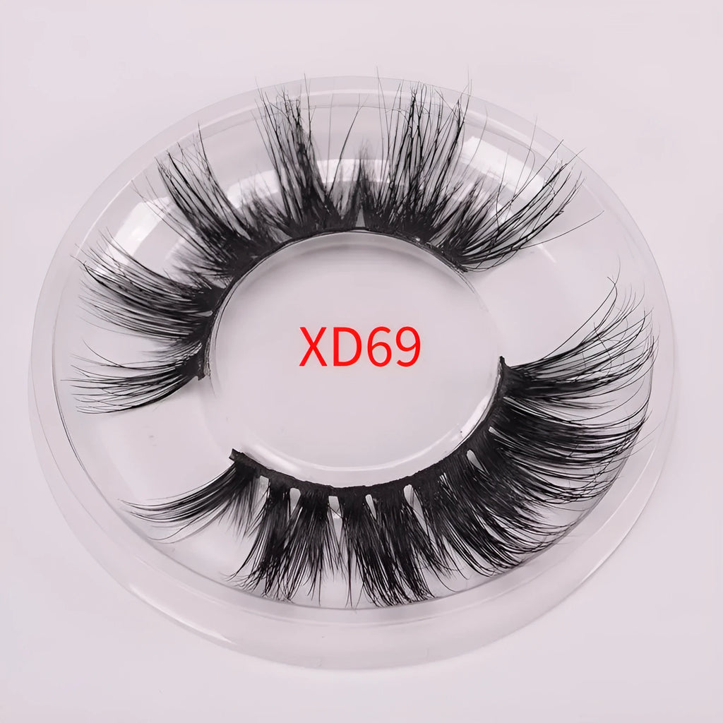 A pair of handcrafted 5D mink false eyelashes with applicator brush and storage case on a clean background.